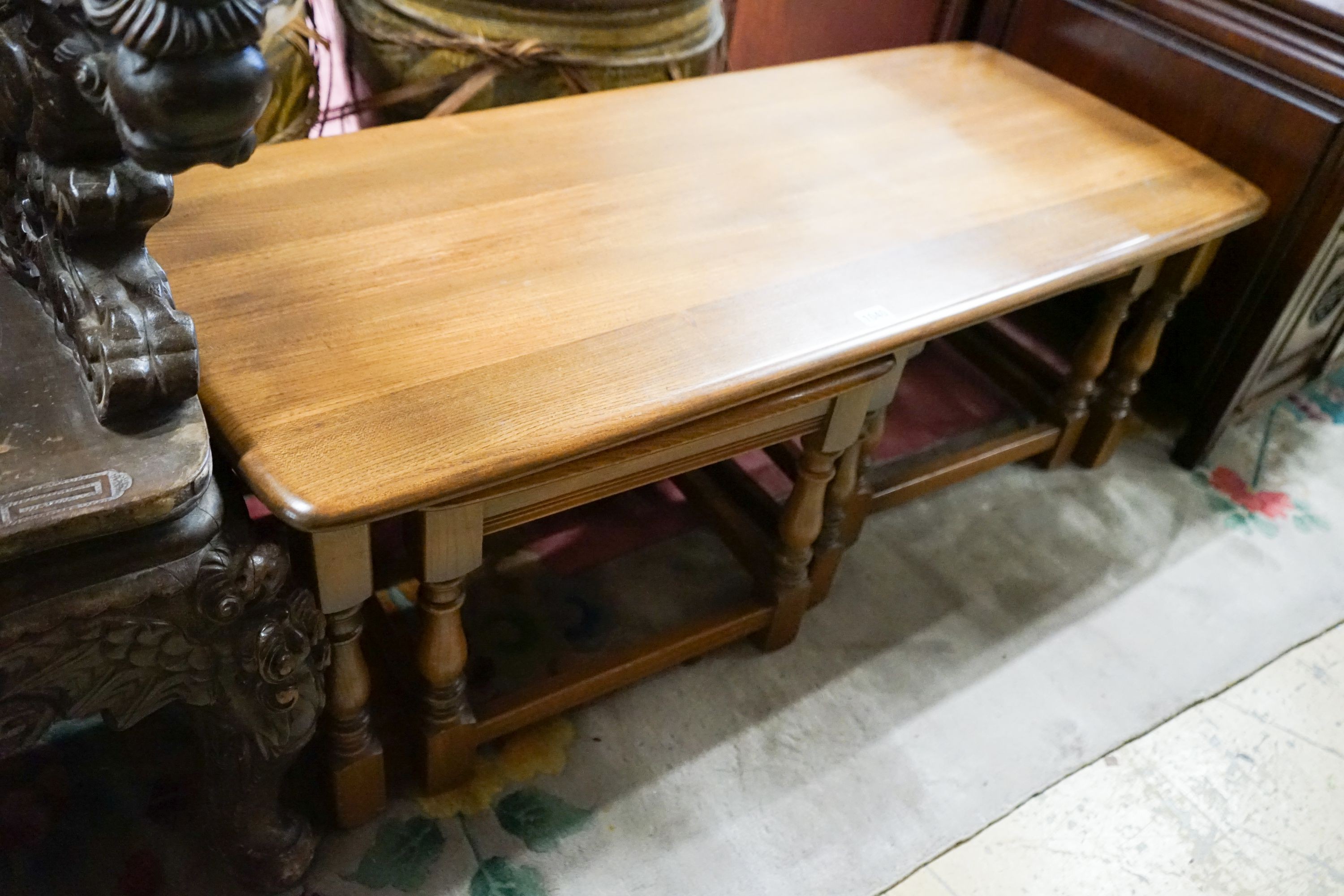 A nest of three Ercol elm tables, largest width 114cm, depth 49cm, height 41cm